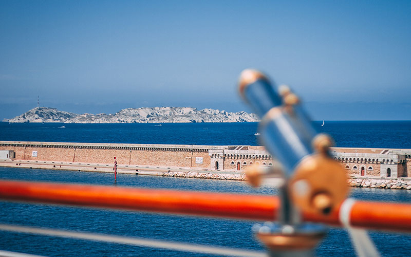 Bright blue waters with a small island out to sea