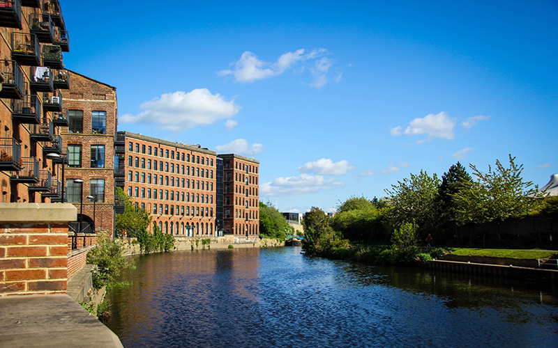 A river flowing next to buildings in Leeds